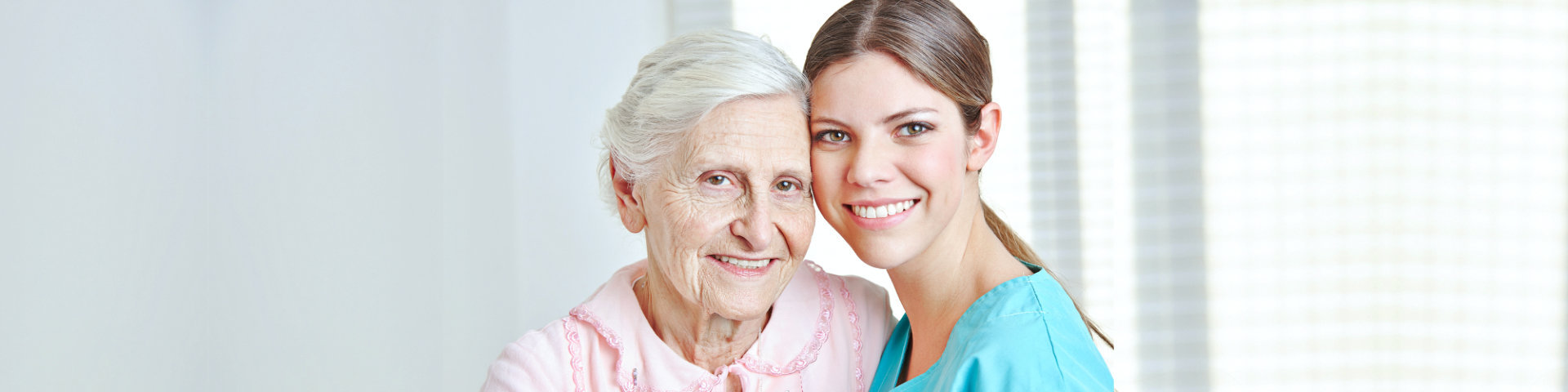 Caregiver embracing happy senior